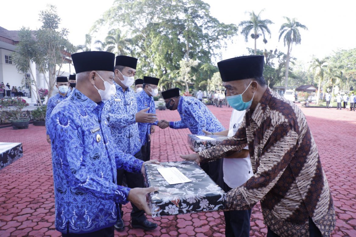 Bupati Asahan tengah memberikan penali kasih kepada salah seorang ASN yang memasuki masa pensiun dalam acara HKN | Foto: Dinas Kominfo Asahan