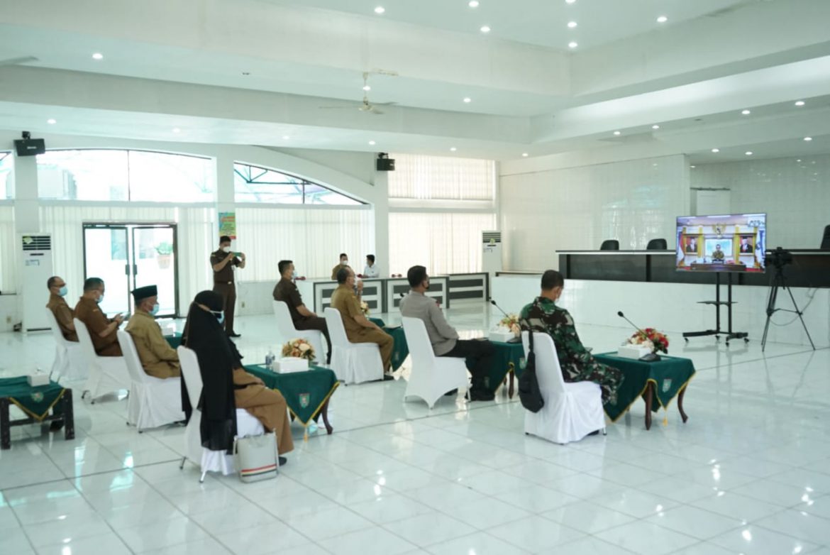 Bupati Asahan,H.Surya Bsc dan Forkopimda tampak memgikuti petunjuk prokes secara virtual di Aula Melati Kantor Bupati Asahan