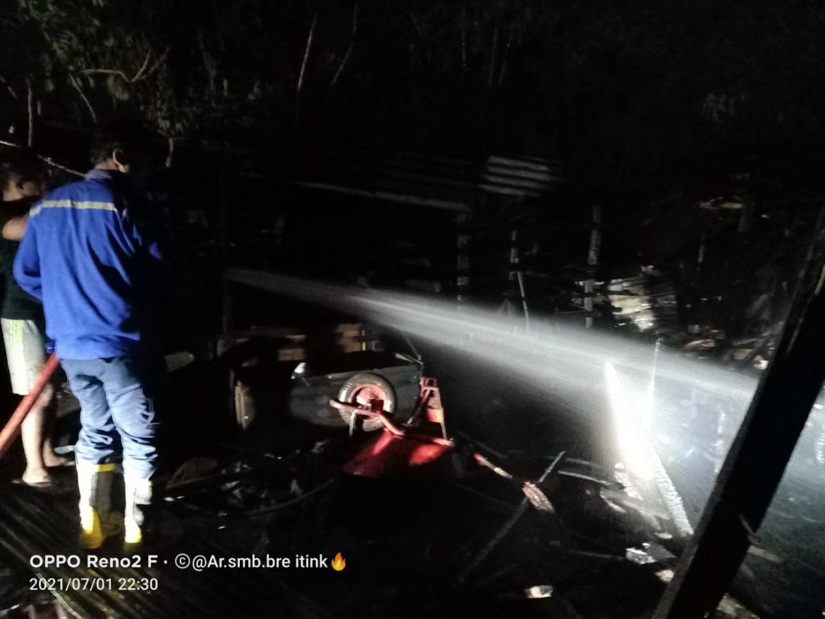 Damkar Kabanjahe beserta Masyarakat berupaya memadamkan api.