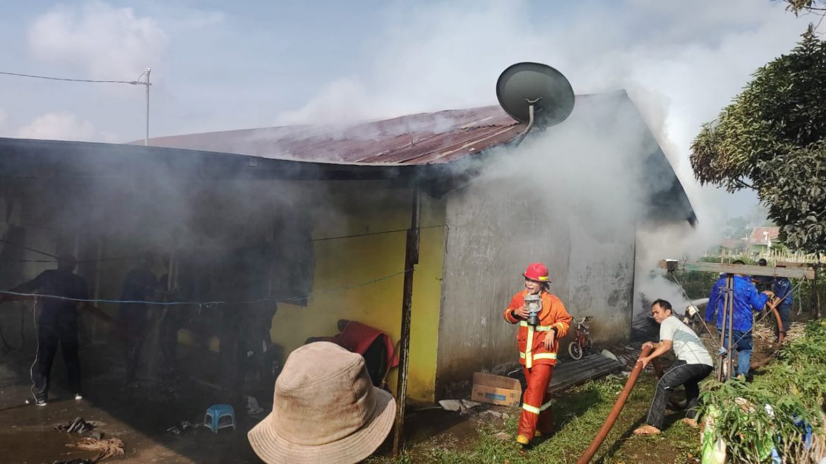 Damkar Kabanjahe berserta masyarakat dan pihak kepolisian berusaha memadamkan api